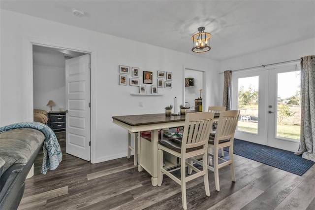 dining room with a chandelier, dark hardwood / wood-style flooring, and french doors