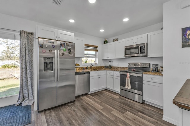 kitchen featuring stone counters, white cabinetry, sink, stainless steel appliances, and dark hardwood / wood-style flooring