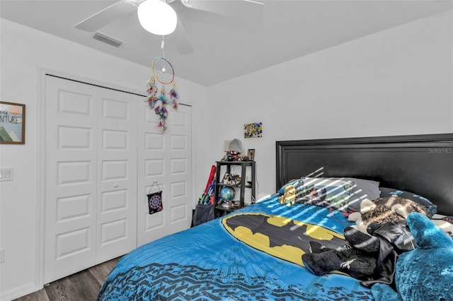 bedroom with ceiling fan, dark wood-type flooring, and a closet