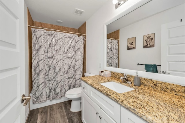 bathroom with hardwood / wood-style flooring, vanity, curtained shower, and toilet