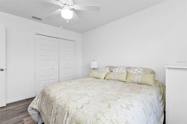 bedroom with dark hardwood / wood-style flooring, ceiling fan, and a closet