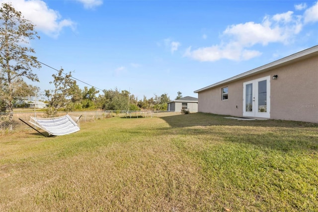 view of yard featuring french doors and a trampoline