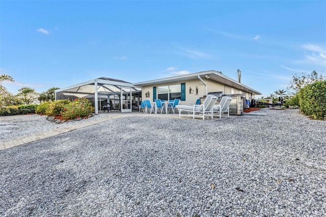 view of front of home featuring glass enclosure and a patio area