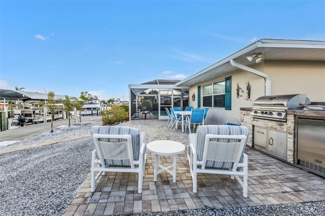 view of patio / terrace with a lanai, grilling area, and exterior kitchen