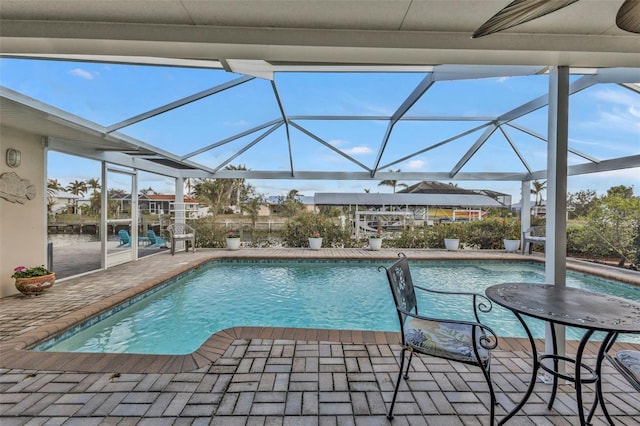 view of swimming pool with glass enclosure and a patio