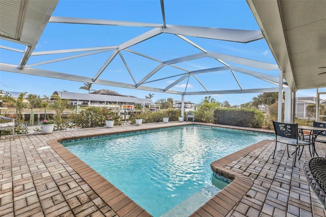 view of swimming pool with a patio area and a lanai