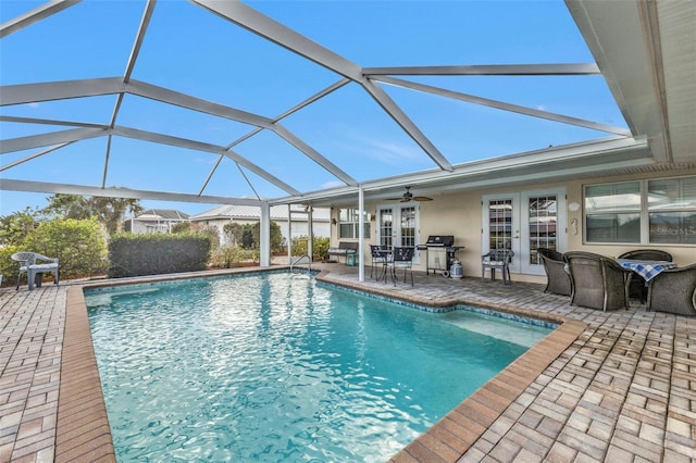 view of swimming pool featuring french doors, a lanai, a patio area, and ceiling fan