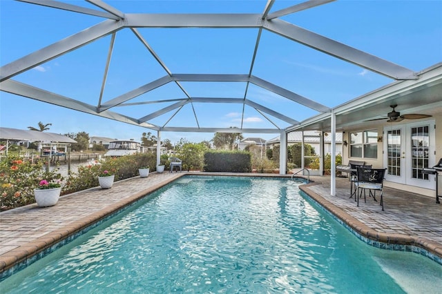 view of pool featuring glass enclosure, a patio, and french doors