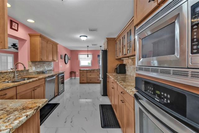 kitchen with sink, hanging light fixtures, tasteful backsplash, wine cooler, and appliances with stainless steel finishes