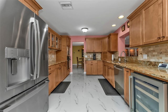 kitchen featuring wine cooler, decorative backsplash, sink, and stainless steel appliances