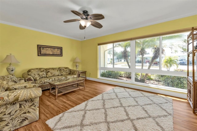 living room featuring ceiling fan, light hardwood / wood-style flooring, and crown molding