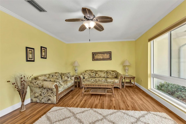 living room with ceiling fan, crown molding, and light hardwood / wood-style floors