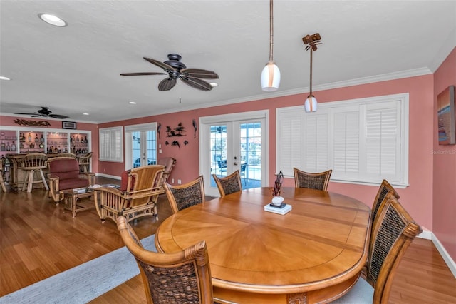 dining space with ceiling fan, french doors, crown molding, and light wood-type flooring