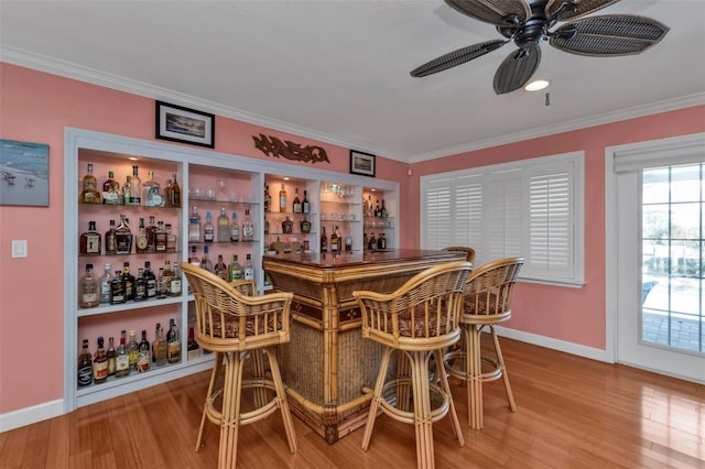 bar with hardwood / wood-style floors, ceiling fan, and crown molding