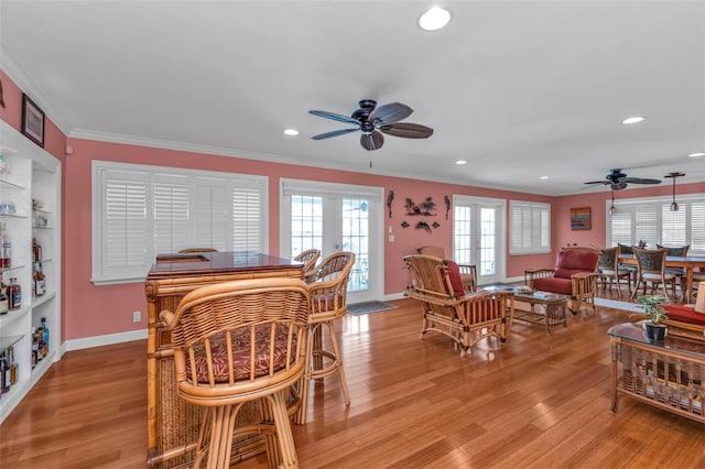 dining room featuring ceiling fan, light wood-type flooring, crown molding, and french doors