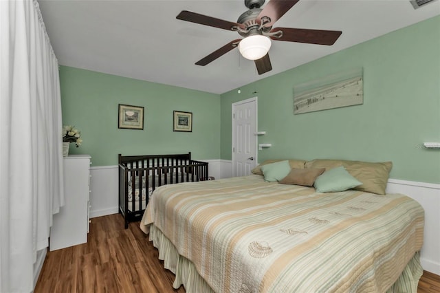 bedroom with dark hardwood / wood-style flooring and ceiling fan