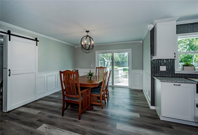 dining room with a chandelier, dark hardwood / wood-style flooring, a barn door, and crown molding