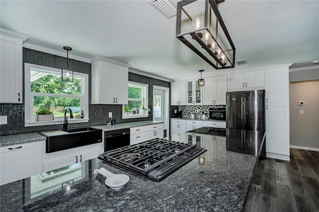 kitchen with white cabinets, sink, hanging light fixtures, black dishwasher, and stainless steel refrigerator