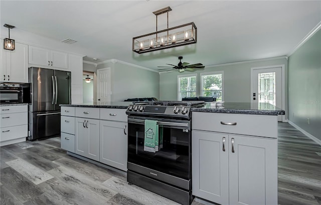 kitchen featuring stainless steel fridge, ceiling fan, pendant lighting, black range, and white cabinetry