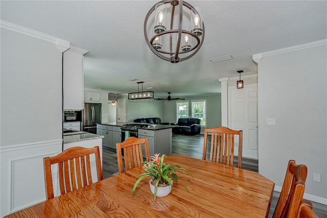 dining room featuring hardwood / wood-style flooring, sink, ceiling fan with notable chandelier, and ornamental molding