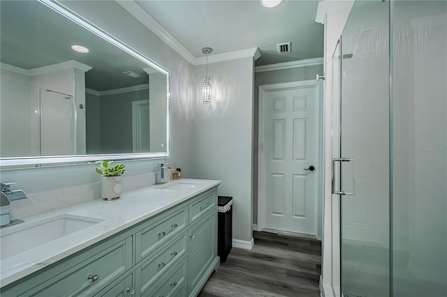 bathroom featuring wood-type flooring, vanity, crown molding, and a shower with shower door