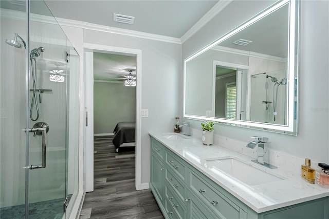 bathroom with ceiling fan, walk in shower, ornamental molding, vanity, and hardwood / wood-style flooring