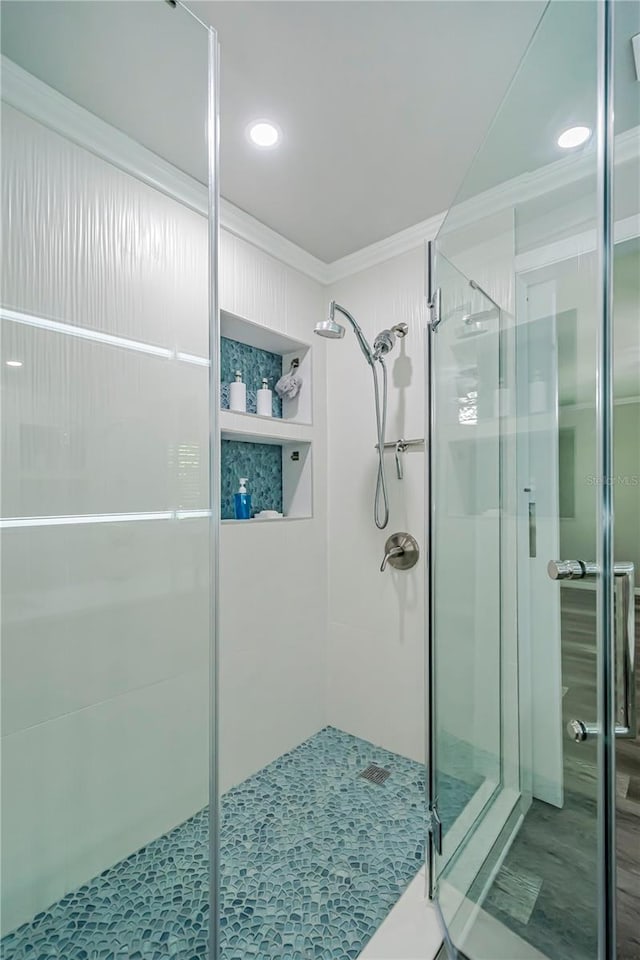 bathroom featuring an enclosed shower and ornamental molding