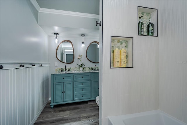 bathroom with ornamental molding, vanity, wood-type flooring, and toilet