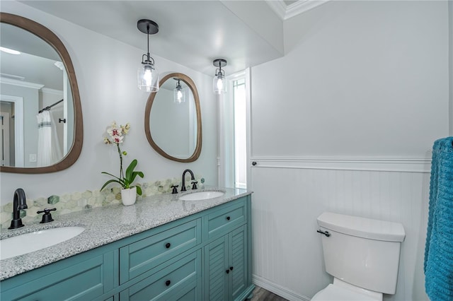 bathroom with vanity, toilet, and crown molding