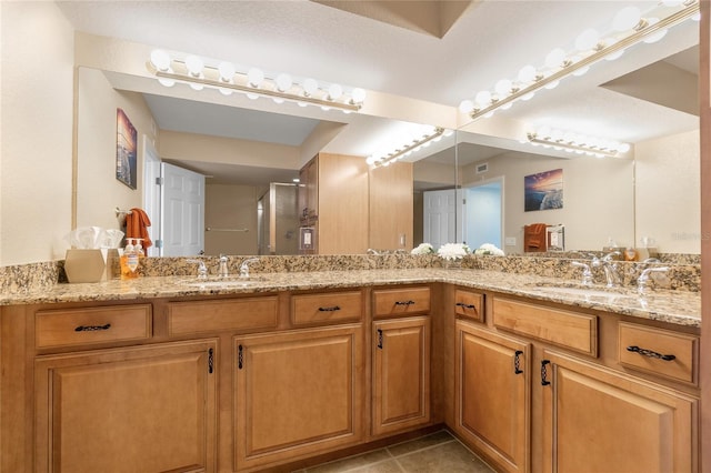 bathroom featuring walk in shower, vanity, and tile patterned floors