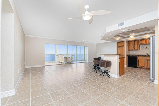 unfurnished living room with ceiling fan, a raised ceiling, crown molding, and light tile patterned flooring