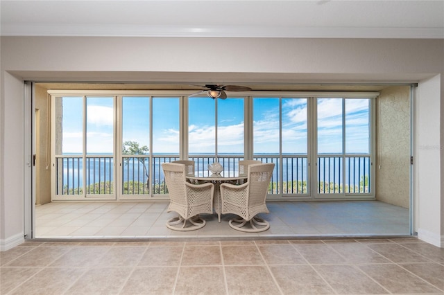 sunroom with ceiling fan, plenty of natural light, and a water view