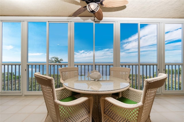 sunroom / solarium featuring ceiling fan, a water view, and plenty of natural light