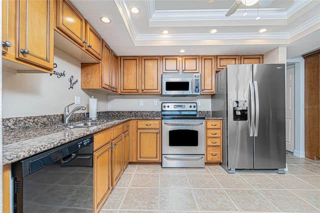 kitchen featuring a raised ceiling, sink, appliances with stainless steel finishes, and dark stone countertops