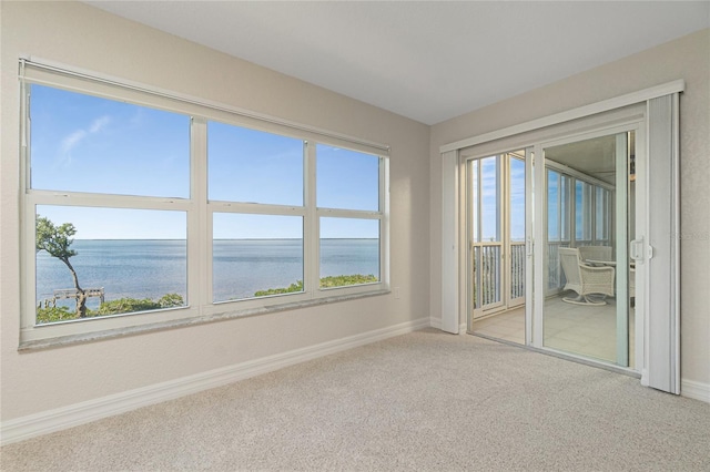 carpeted empty room featuring a water view