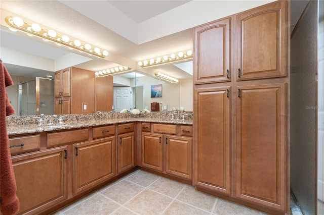 bathroom with vanity, tile patterned flooring, and an enclosed shower