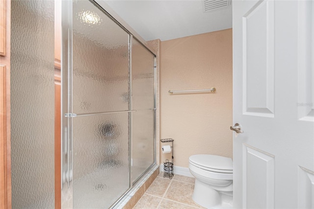 bathroom with toilet, an enclosed shower, and tile patterned floors