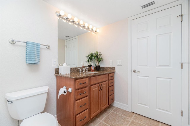 bathroom featuring toilet, tile patterned flooring, and vanity