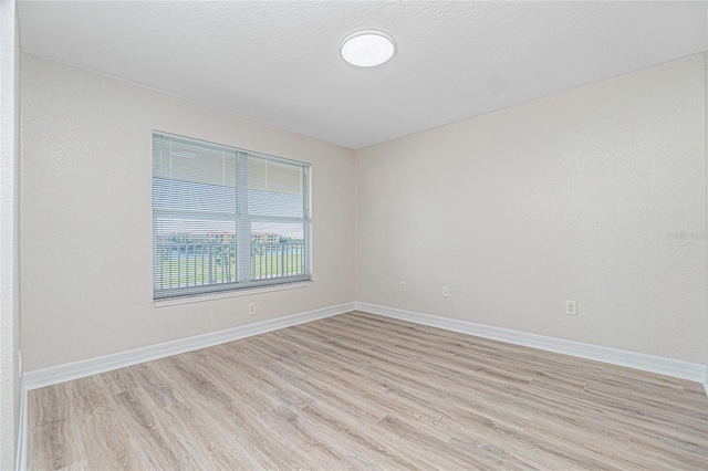 unfurnished room with a textured ceiling and light hardwood / wood-style floors