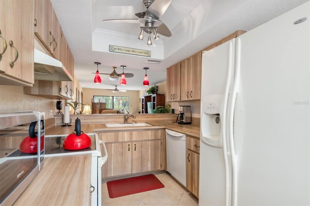 kitchen featuring butcher block countertops, kitchen peninsula, sink, a tray ceiling, and white appliances