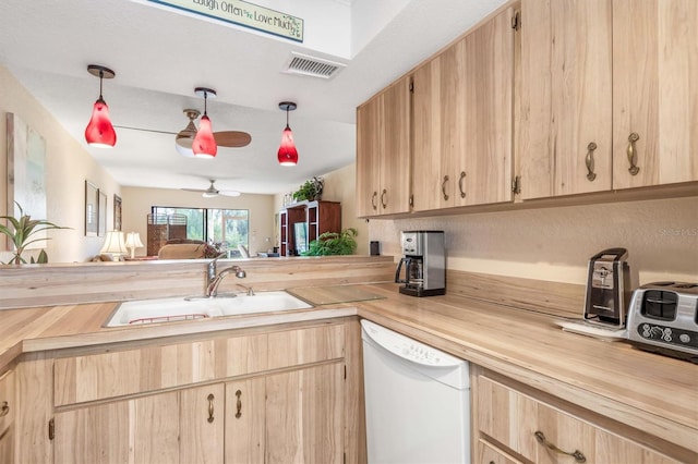 kitchen featuring hanging light fixtures, wood counters, and white dishwasher