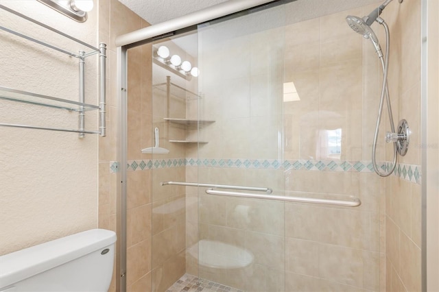 bathroom featuring toilet, a textured ceiling, and walk in shower