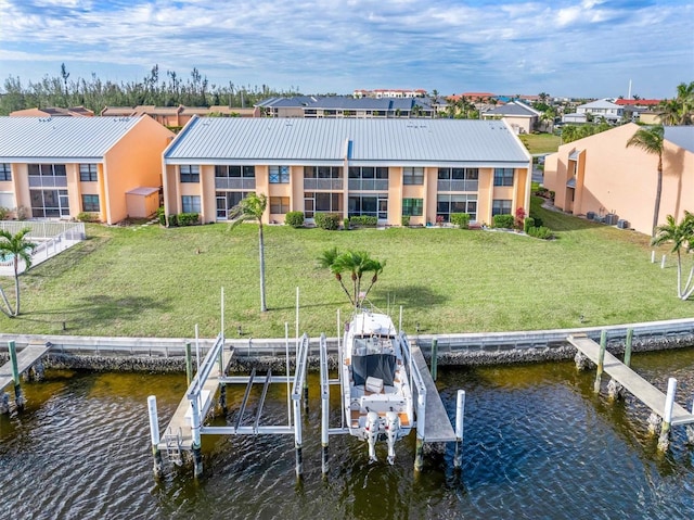 view of dock with a water view and a yard