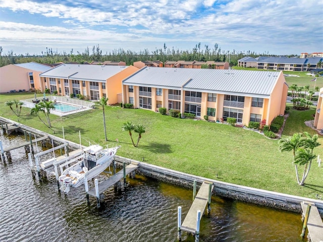 view of dock with a yard and a water view