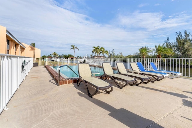 view of swimming pool with a water view and a patio