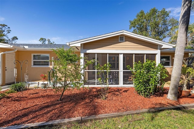 rear view of house featuring a sunroom