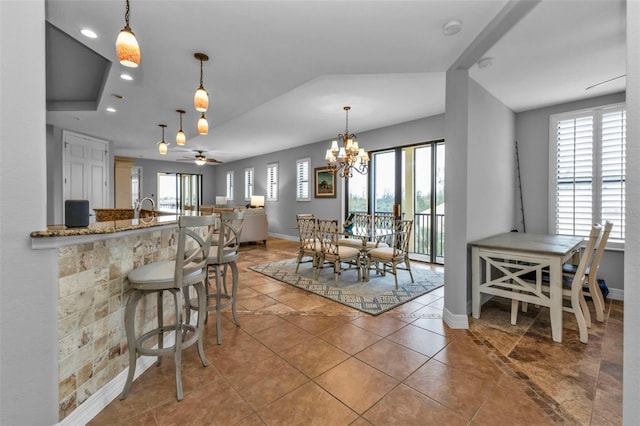 dining area featuring tile patterned floors and ceiling fan with notable chandelier