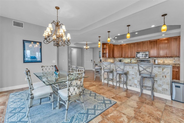 dining room with a tray ceiling and an inviting chandelier