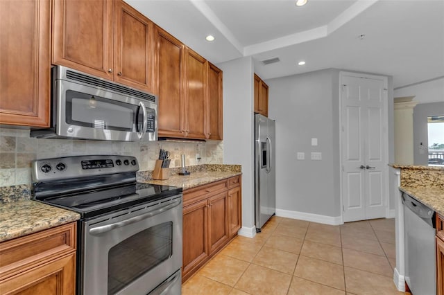 kitchen featuring tasteful backsplash, light stone countertops, light tile patterned floors, and stainless steel appliances