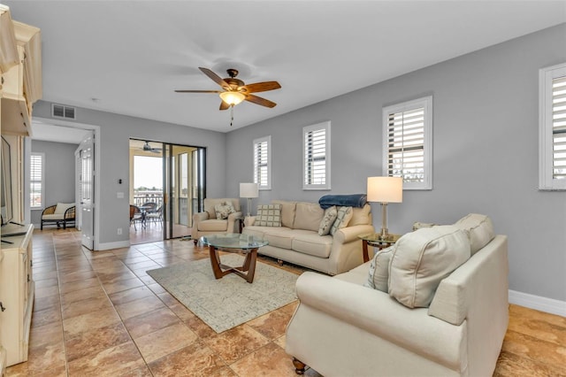 tiled living room with ceiling fan and a healthy amount of sunlight